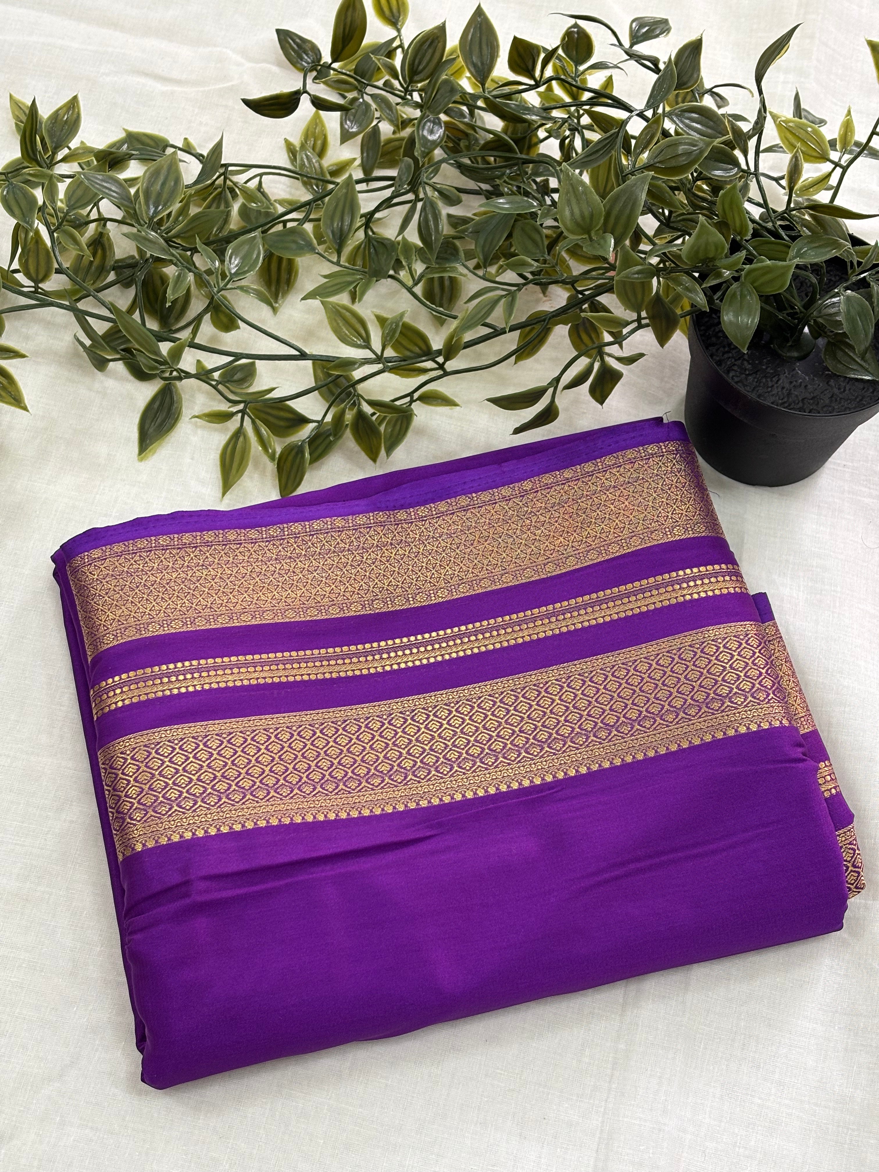 Purple saree with gold border on a white background